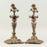 A GOOD PAIR OF CAST PLATED ROCOCO CANDLESTICKS. 38cms high.