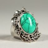 A SILVER AND TURQUOISE RING.