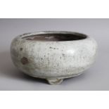 AN EARLY CHINESE SPECKLED CELADON CIRCULAR BOWL, on three legs. 22cms diameter.