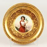 A VIENNA CIRCULAR PORCELAIN PLATE "DISTEL", painted with a young girl holding a sprig of holly,