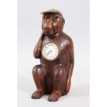 A BLACK FOREST CARVED WOOD MONKEY CLOCK AS A JOCKEY. 26cms high.