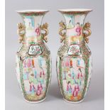 A PAIR OF CANTON CHINESE VASES, painted with four panels and vignettes of figures and birds. 26cms
