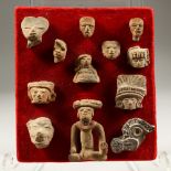 A COLLECTION OF TWELVE PRE-COLUMBIAN TERRACOTTA PIECES, on a velvet background.
