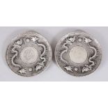 TWO WHITE METAL COIN INSET CIRCULAR DISHES. 10cms diameter.