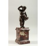 A 16TH-17TH CENTURY BRONZE PUTTI holding a snake, on a marble plinth. 12cms high.