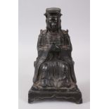 A MING DYNASTY BRONZE SEATED FIGURE OF AN OFFICIAL. 24cms high.