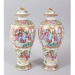 A PAIR OF CANTON CHINESE VASES AND COVERS, painted with panels of figures, birds, flowers and