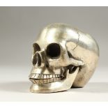 A SILVER PLATED MODEL OF A SKULL. 12cms long.