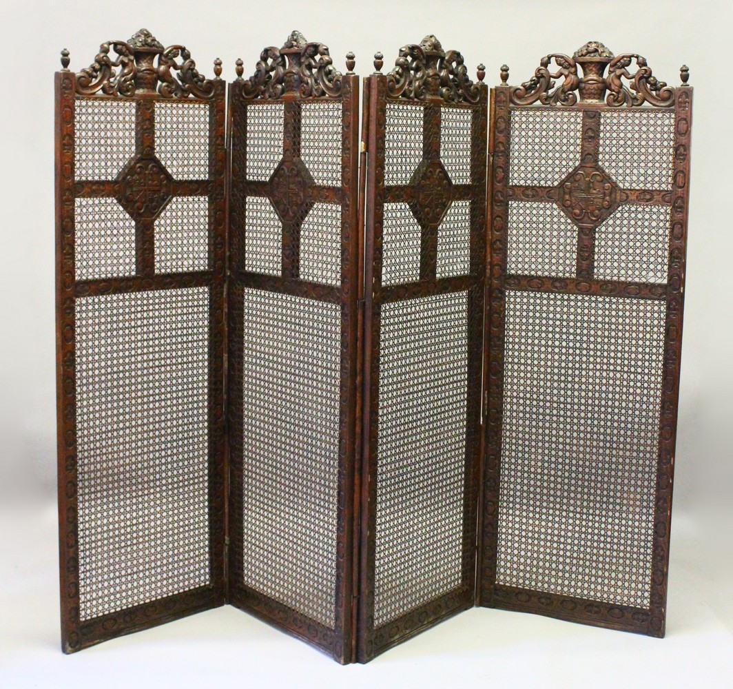 A LARGE BERGERE OAK FOUR FOLD SCREEN, the top carved with cupids and scrolls. 244cms wide overall