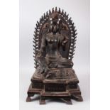 A LARGE SEATED BRONZE EASTERN DEITY, with flaming halo. 61cms high.