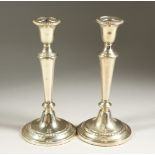 A PAIR OF SILVER CIRCULAR CANDLESTICKS. 24cms high.