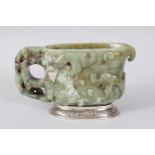 A CHINESE 18TH CENTURY CARVED JADE LIBATION CUP, the sides carved with animals and scrolls, on a