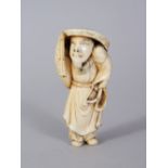 A JAPANESE CARVED IVORY NETSUKE OF A MAN. 6cms long.