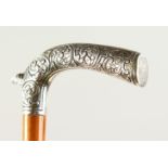 AN EDWARDIAN WALKING CANE, with very heavy silver engraved handle. 86cms long.