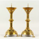 A GOOD PAIR OF GOTHIC DESIGN BRASS PRICKET CANDLESTICKS. 35cms high.