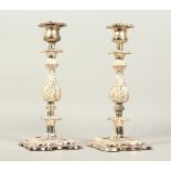 A GOOD PAIR OF PLATED CANDLESTICKS, on square bases. 30cms high.