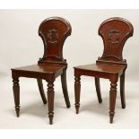 A GOOD PAIR OF LATE REGENCY MAHOGANY HALL CHAIRS, with shaped backs, solid seats, on turned legs.