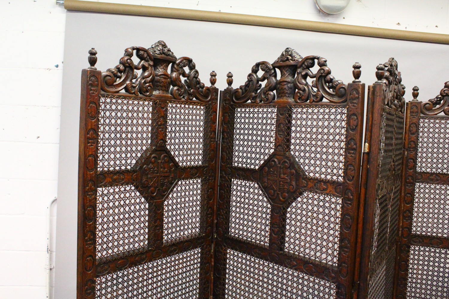 A LARGE BERGERE OAK FOUR FOLD SCREEN, the top carved with cupids and scrolls. 244cms wide overall - Image 5 of 10