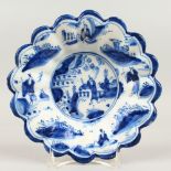AN 18TH CENTURY DUTCH TIN GLAZE BLUE AND WHITE SHAPED DISH, with Chinese design. 20cms diameter.