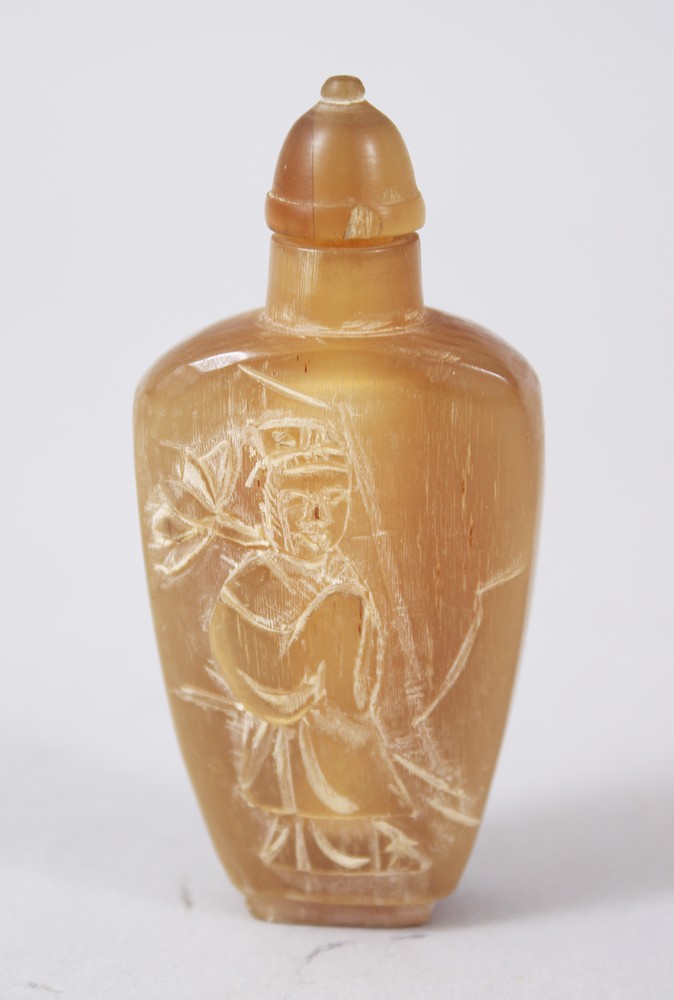 A 19TH CENTURY CHINESE RHINOCEROS HORN SNUFF BOTTLE, the front carved in relief to depict a figure