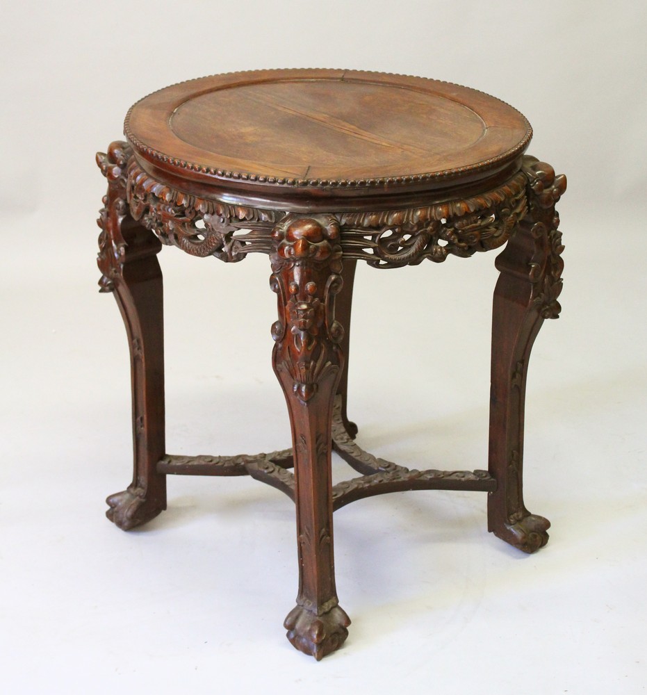 A CHINESE REDWOOD STAND, with inset hardstone top on carved legs. 73cm diameter.