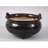 A 19TH CENTURY CHINESE BLACK GLAZED WU JIN YOU TRIPLE FOOT POTTERY TRIPOD CENSER, stood upon three