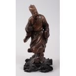 A 19TH CENTURY CHINESE HARDWOOD CARVED FIGURE OF A SAGE, modeled holding a book other item, fixed to