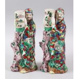 A PAIR OF JAPANESE MEIJI PERIOD KUTANI PORCELAIN CANDLESTICKS, depicting two immortals holding vases