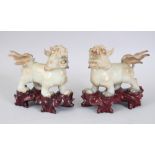 A PAIR OF 20TH CENTURY CHINESE JADE / SOAPSTONE LION DOGS ON STANDS, the pair of fo dogs on fitted