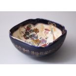 A JAPANESE MEIJI PERIOD SATSUMA BOWL, the blue ground with decorated scenes of figures in parade