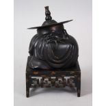 A JAPANESE MEIJI / TAISHO PERIOD BRONZE BUDDHA / HOTEI ON STAND, depicting a cast hollow bronze