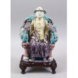 A GOOD 19TH CENTURY CHINESE KANGXI STYLE SANCAI PORCELAIN FIGURE ON STAND OF AN OFFICIAL, the