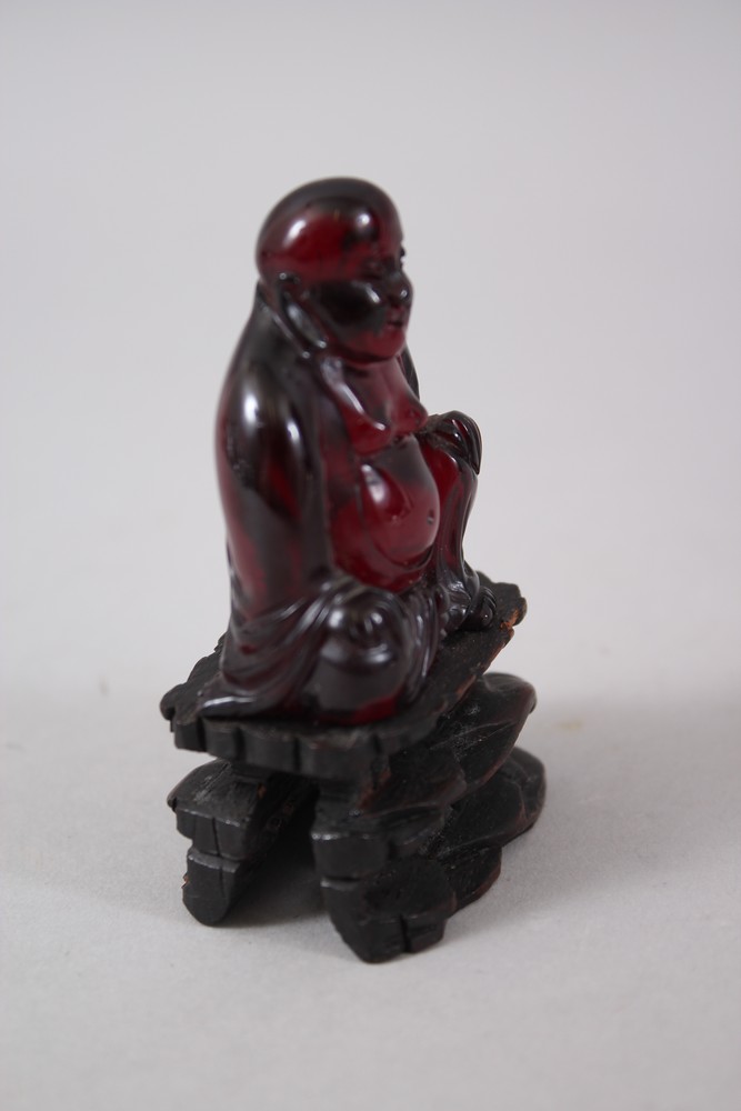 A GOOD 19TH CENTURY CHINESE CHERRY AMBER CARVED FIGURE OF BUDDHA, seated upon a carved and pierced - Image 2 of 4