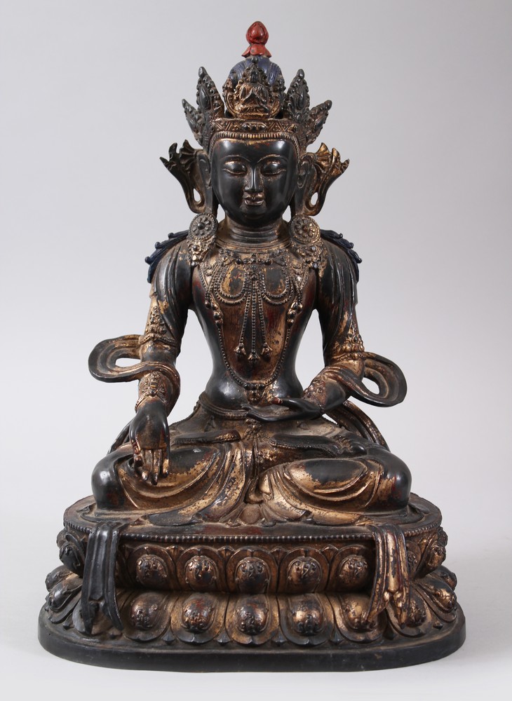 A CHINESE GILT BRONZE FIGURE OF A BUDDHA, seated upon a lotus formed base in a meditating position,