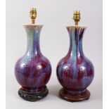 A PAIR OF 19TH CENTURY CHINESE SANG DE BOEUF / FLAMBE PORCELAIN VASES CONVERTED TO LAMPS, with