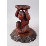 A JAPANESE MEIJI PERIOD CARVED WOOD MONKEY OKIMONO, the monkey carved in a seated position holding a