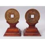 A PAIR OF CHINESE 20TH CENTURY BRONZE BI - DISKS & HARDWOOD STANDS, both with carved dragin and