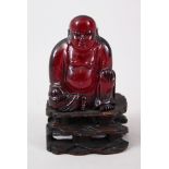 A GOOD 19TH CENTURY CHINESE CHERRY AMBER CARVED FIGURE OF BUDDHA, seated upon a carved and pierced