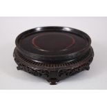 A 19TH CENTURY CHINESE HARDWOOD CARVED CIRCULAR STAND, the frieze of the stand carved and pierced