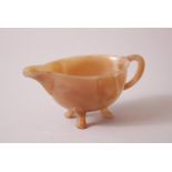 A GOOD CHINESE AGATE LIBATION CUP, sat on three feet with a formed handle and spout, 4.5cm high x