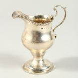 A GEORGE III CREAM JUG with gadrooned edge and circular base. London 1771.