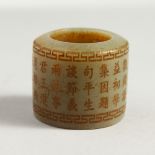 A CHINESE JADE ARCHER'S RING with calligraphy. 3.5cms diameter.