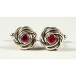 A PAIR OF SILVER RUBY SET KNOT CUFFLINKS.