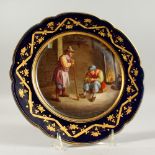 A GOOD SEVRES SHAPED CIRCULAR PLATE, blue and gilt border, the centre painted with figures after
