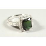 A 14k WHITE GOLD AND DIAMOND RING set with an emerald cut green tourmaline.