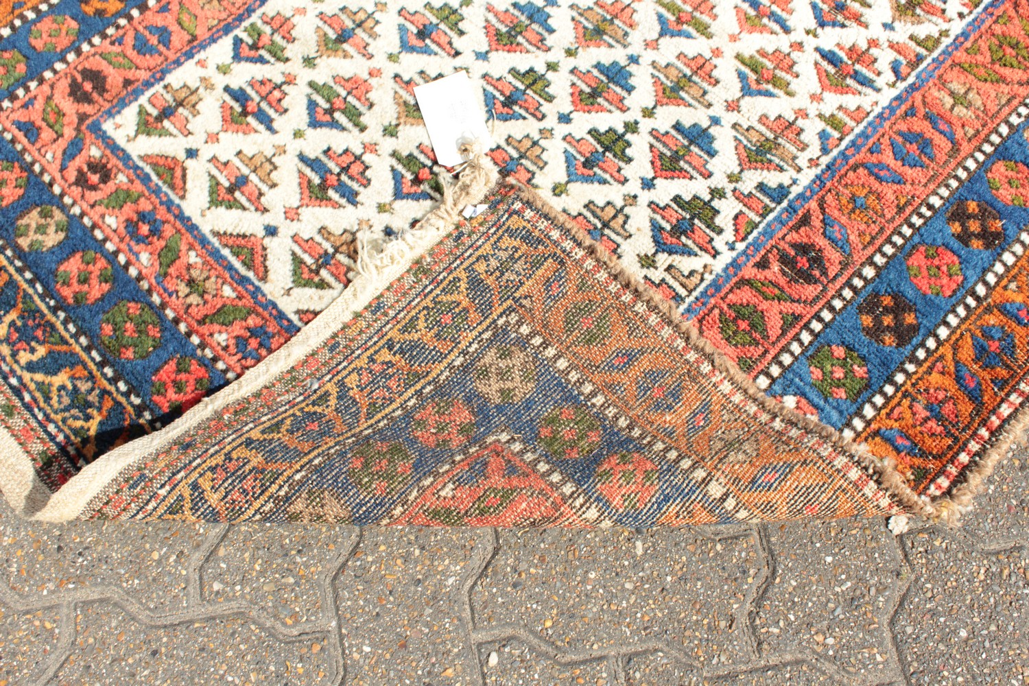 A KURDISH PERSIAN TRIBAL RUG with a key row of motifs on a white ground within a red and blue three - Image 5 of 6