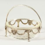 A VICTORIAN CAST SILVER FRAMED BUTTER DISH with star base, the frame with garlands and claw feet.