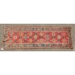 A CAUCASIAN RUNNER with typical motifs in red and blue. 10ft 9ins x 3ft 6ins.