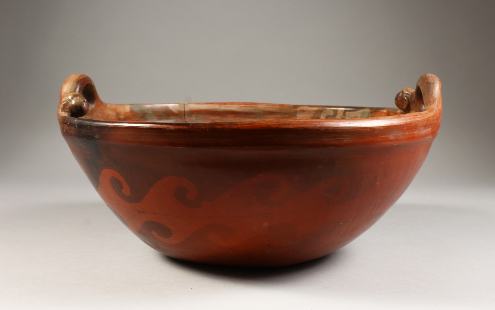 A LARGE PERUVIAN POTTERY CIRCULAR TWO-HANDLED BOWL, with wavy and zigzag pattern, signed CHULUCANAS,