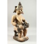 A LARGECARVED WOOD TRIBAL FIGURE, seated mother and baby, with white pigment decoration. 60cms